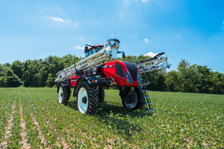 Apache Sprayer with booms brought in sitting in the field.