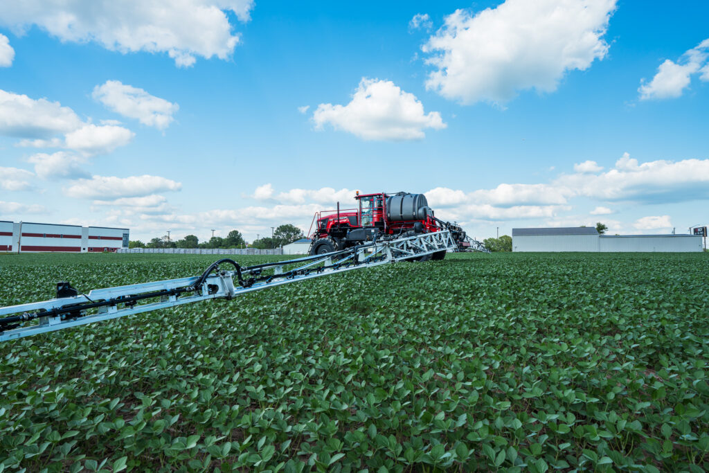 side of apache sprayer with booms extended in bean field